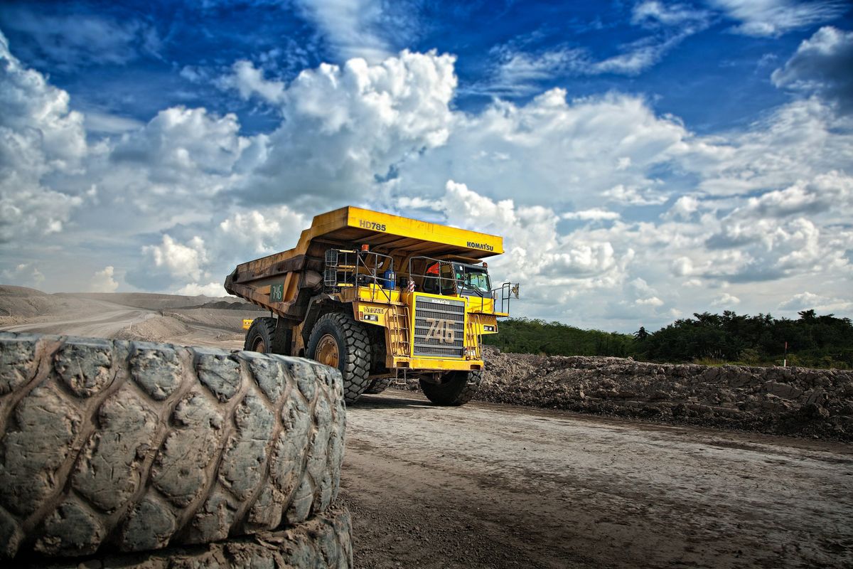 Yellow mining truck on road during daytime.